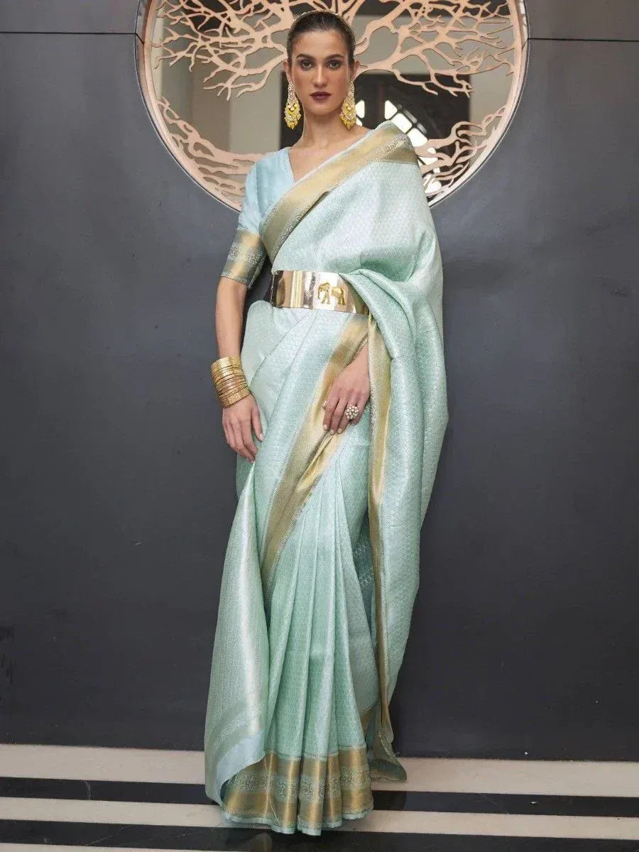 Mint green designer saree with gold border and belt, styled with ethnic jewelry for Indian occasions