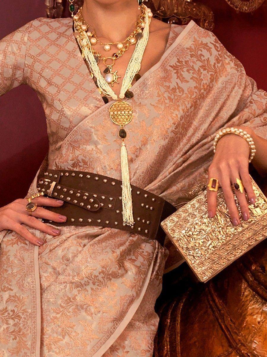 Elegant Indian ethnic gown with gold embroidery, layered necklaces, studded belt, and ornate clutch for festive occasions