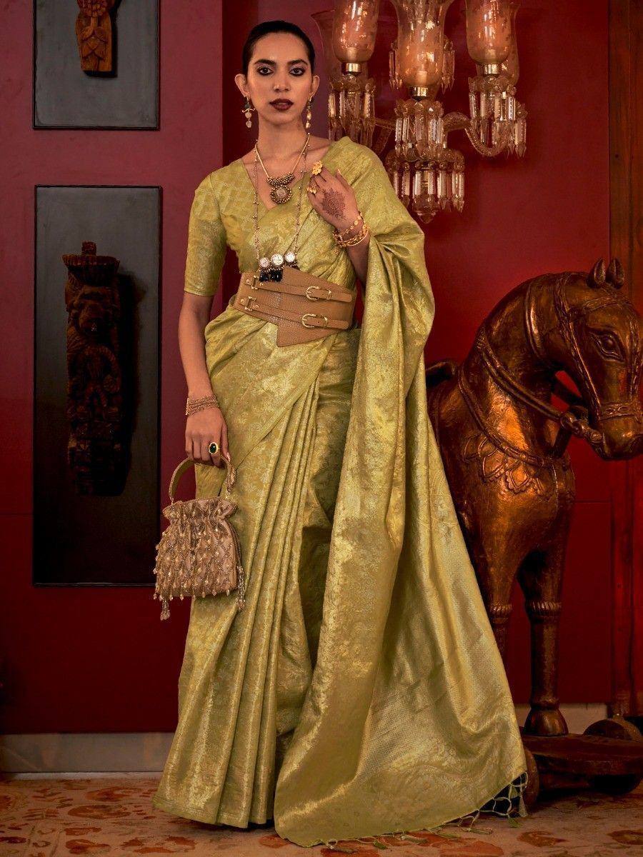 Elegant olive green designer saree with gold embroidery, styled with belt and ethnic jewelry for festive occasions