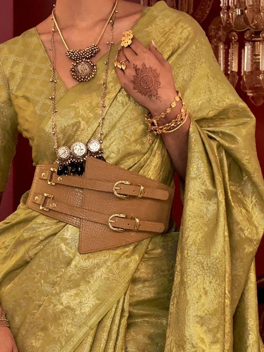 Olive green designer saree with gold jewelry and wide brown belt, perfect for ethnic occasions