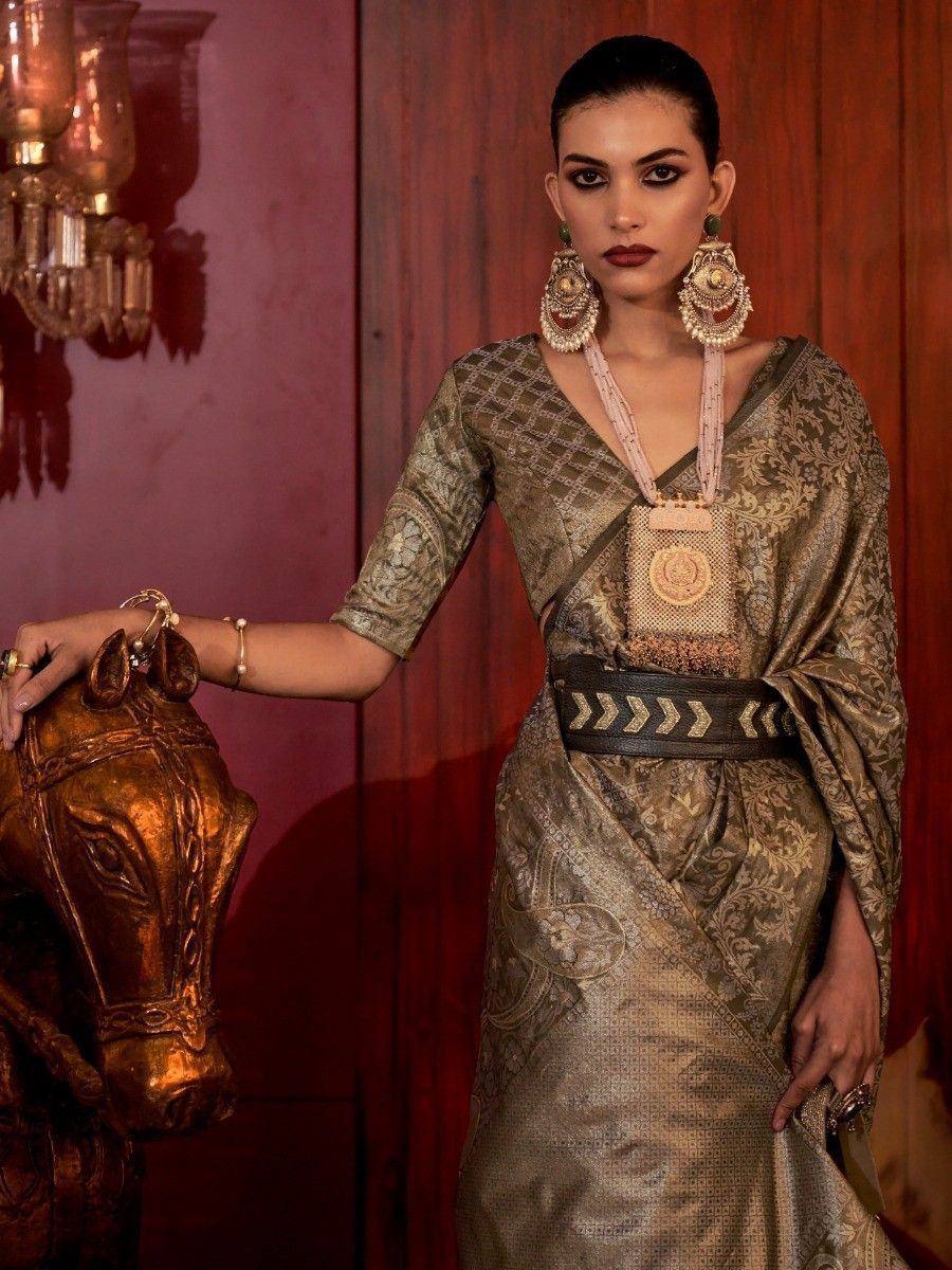 Elegant Indian ethnic gown with gold embroidery, statement jewelry, and designer belt for festive occasions