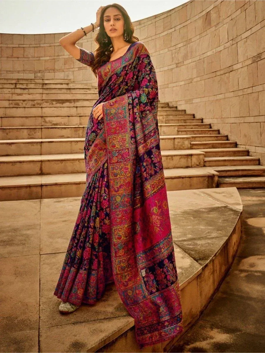 Woman in vibrant floral printed saree with rich pink and purple hues, styled for ethnic occasions