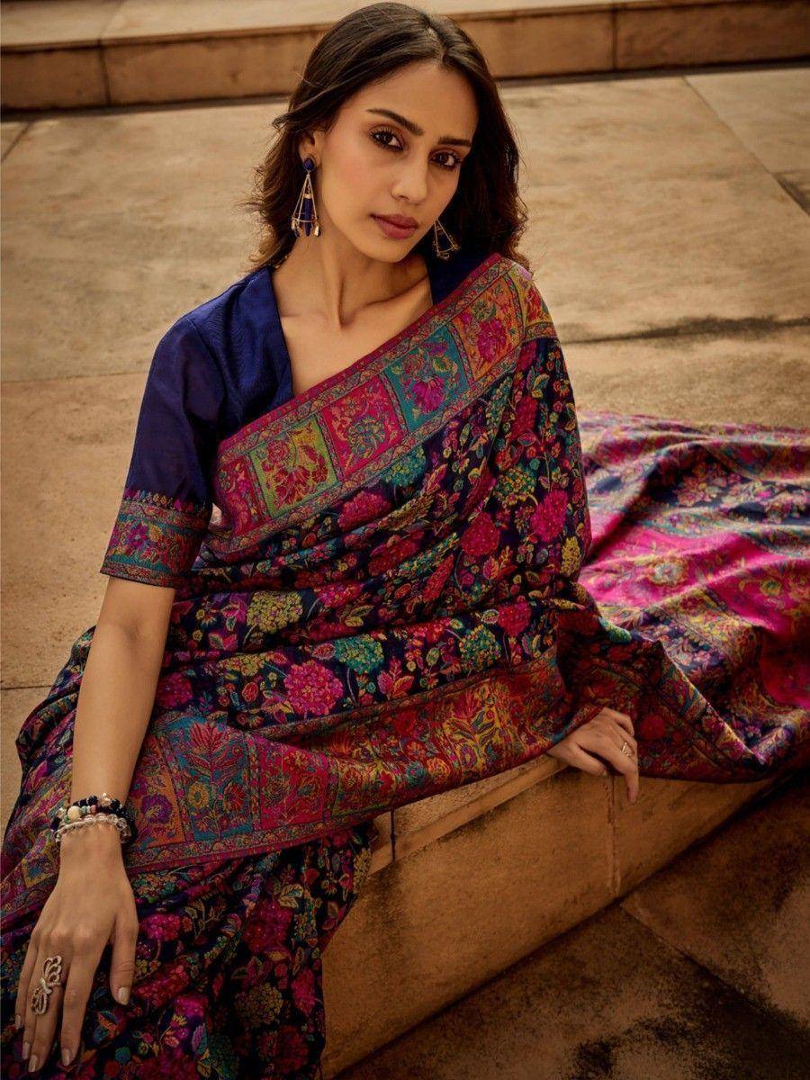 Woman in vibrant floral saree with blue blouse, traditional Indian ethnic wear