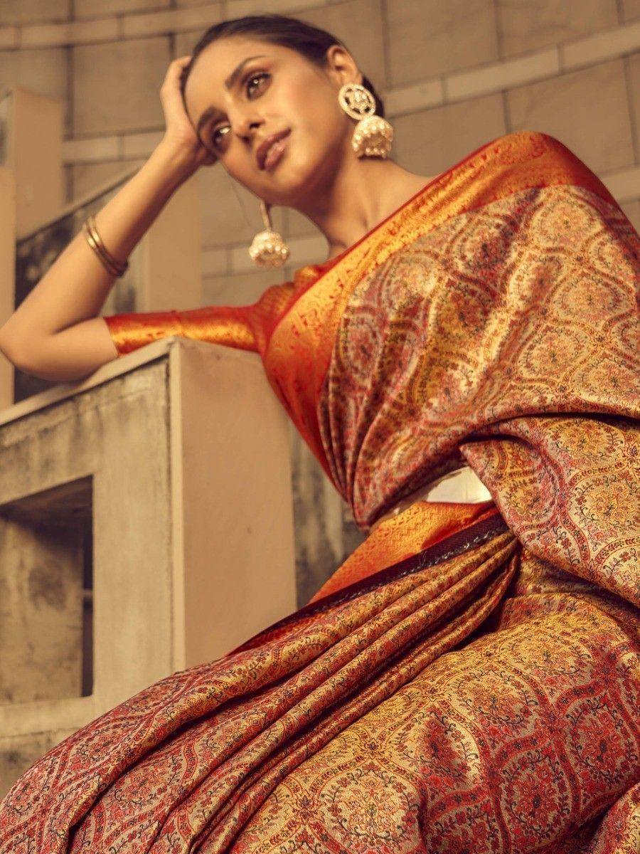 Woman in elegant red and gold printed saree with traditional jewelry, perfect for Indian ethnic wear occasions