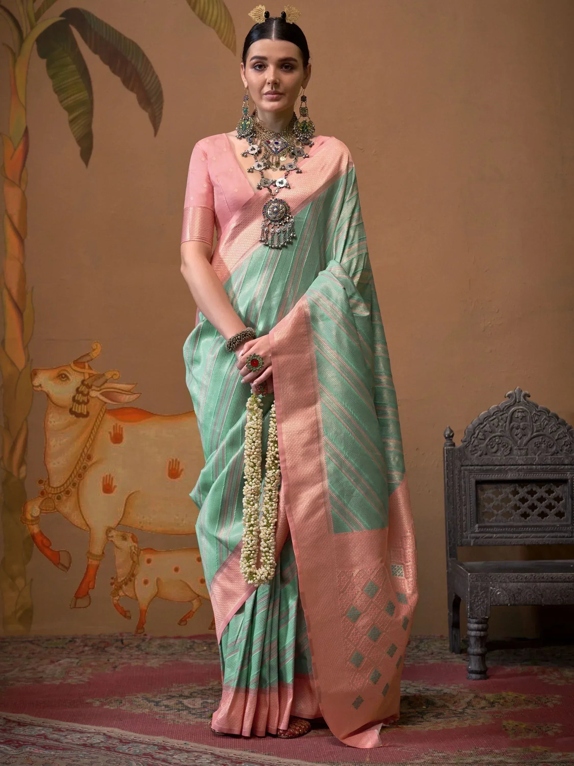 Woman in mint green and pink ethnic saree with traditional jewelry, perfect for Indian occasions