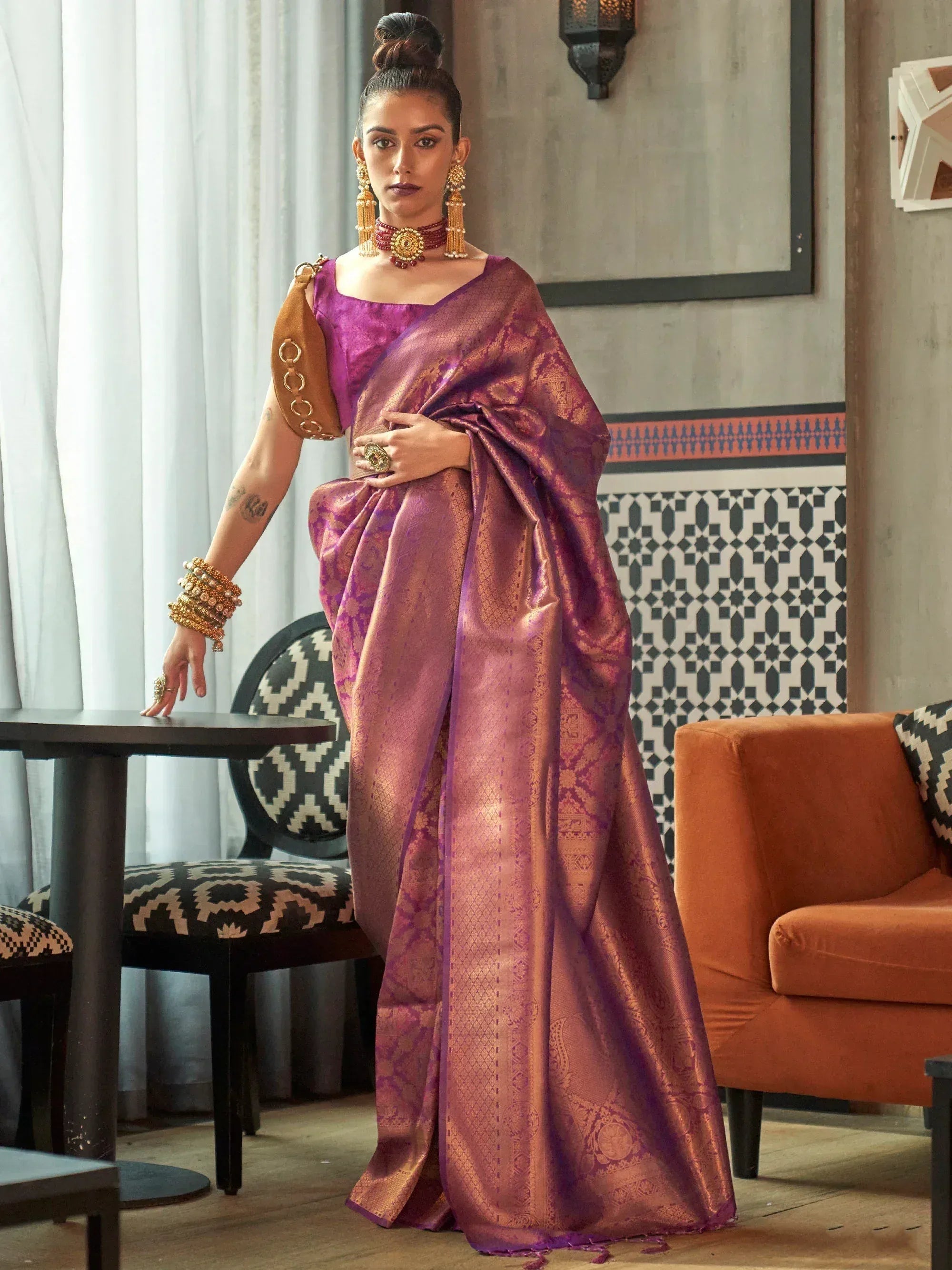 Purple designer saree with gold embroidery, paired with statement jewelry for ethnic wear