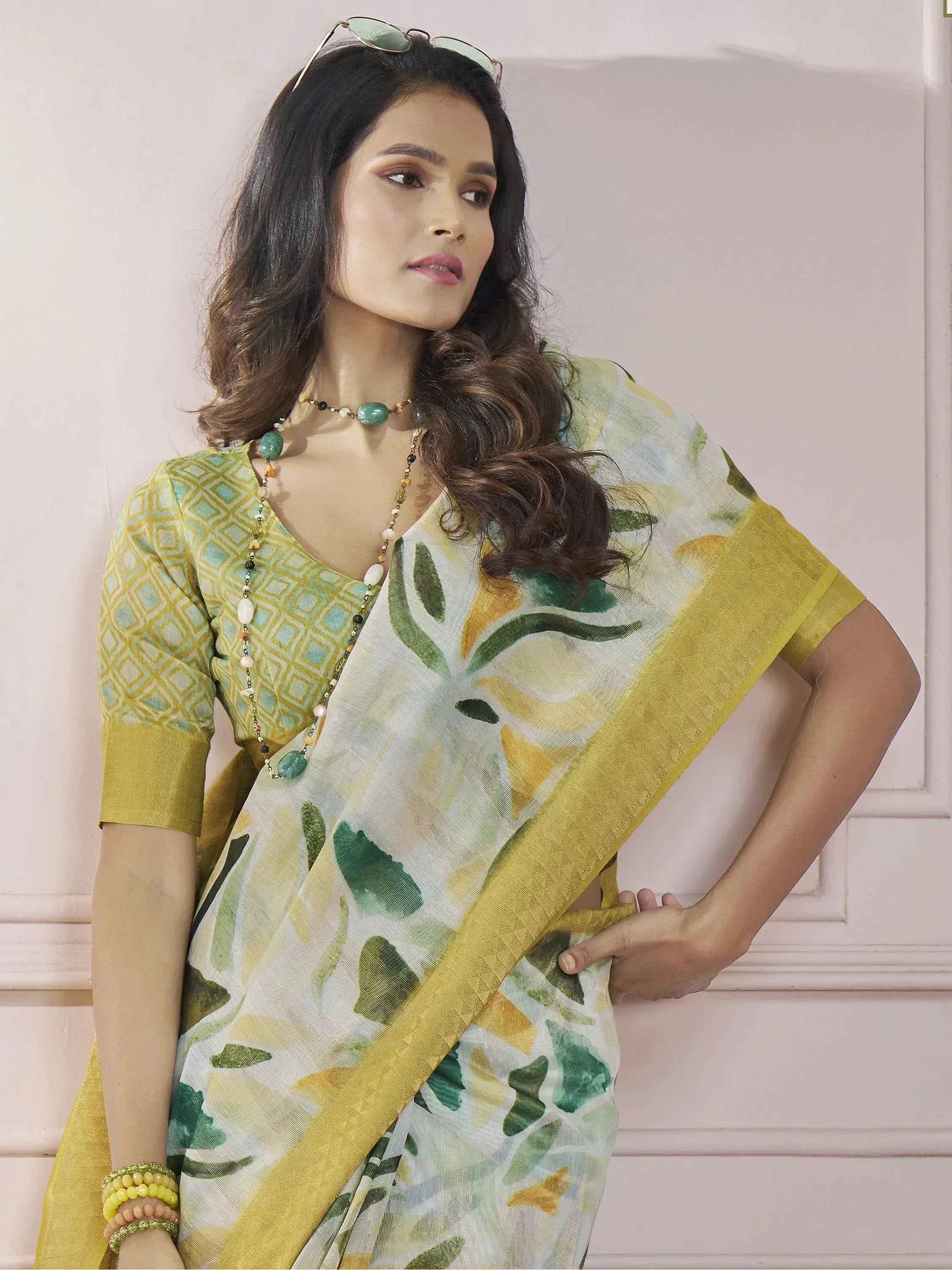 Woman in yellow-green printed saree with geometric blouse, ethnic Indian wear