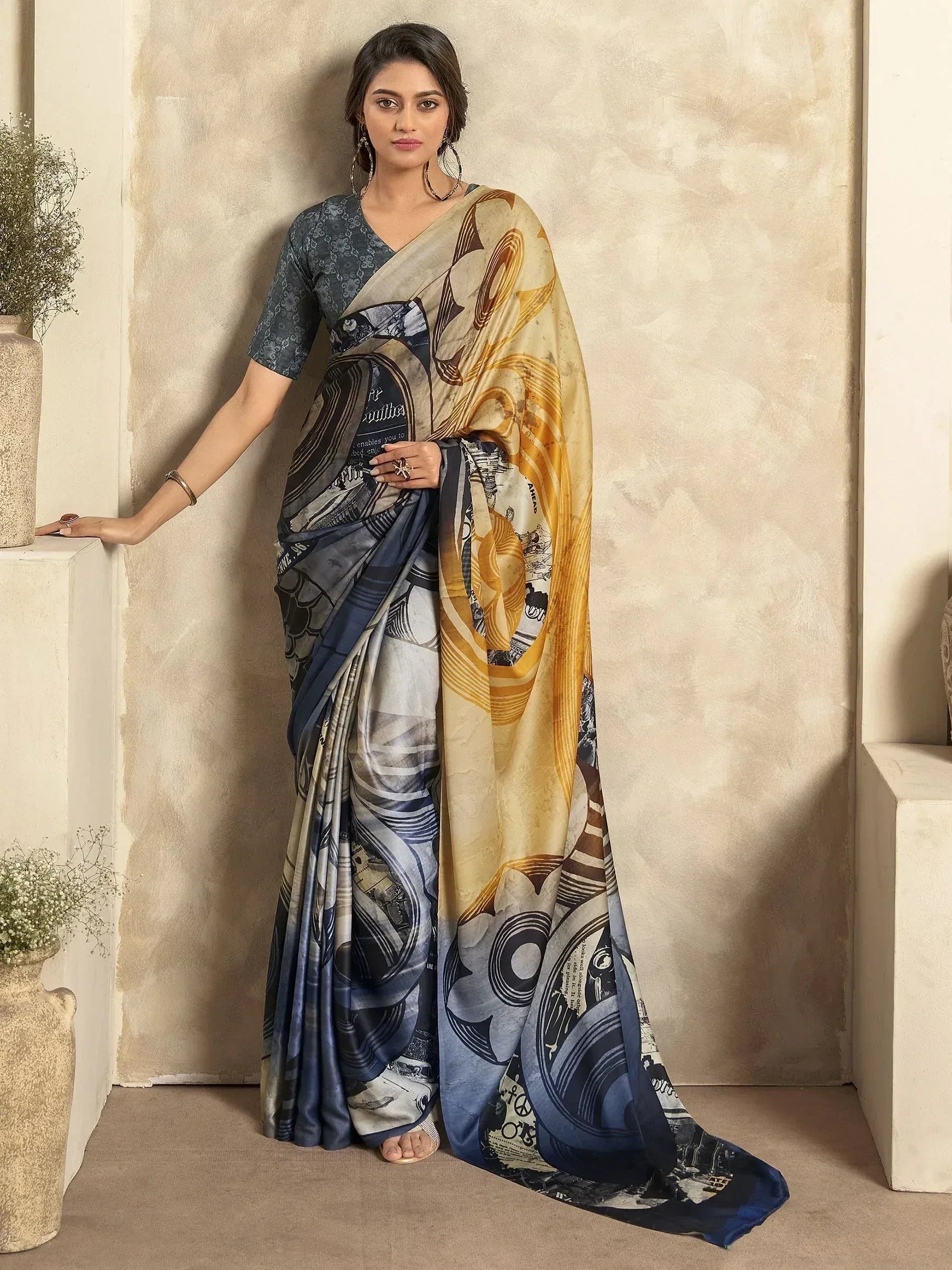 Woman in stylish printed saree with blue and gold abstract design, perfect for ethnic occasions