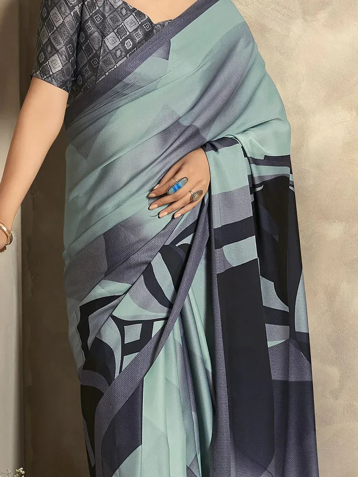 Stylish saree with geometric print in teal and navy, paired with patterned blouse for ethnic wear