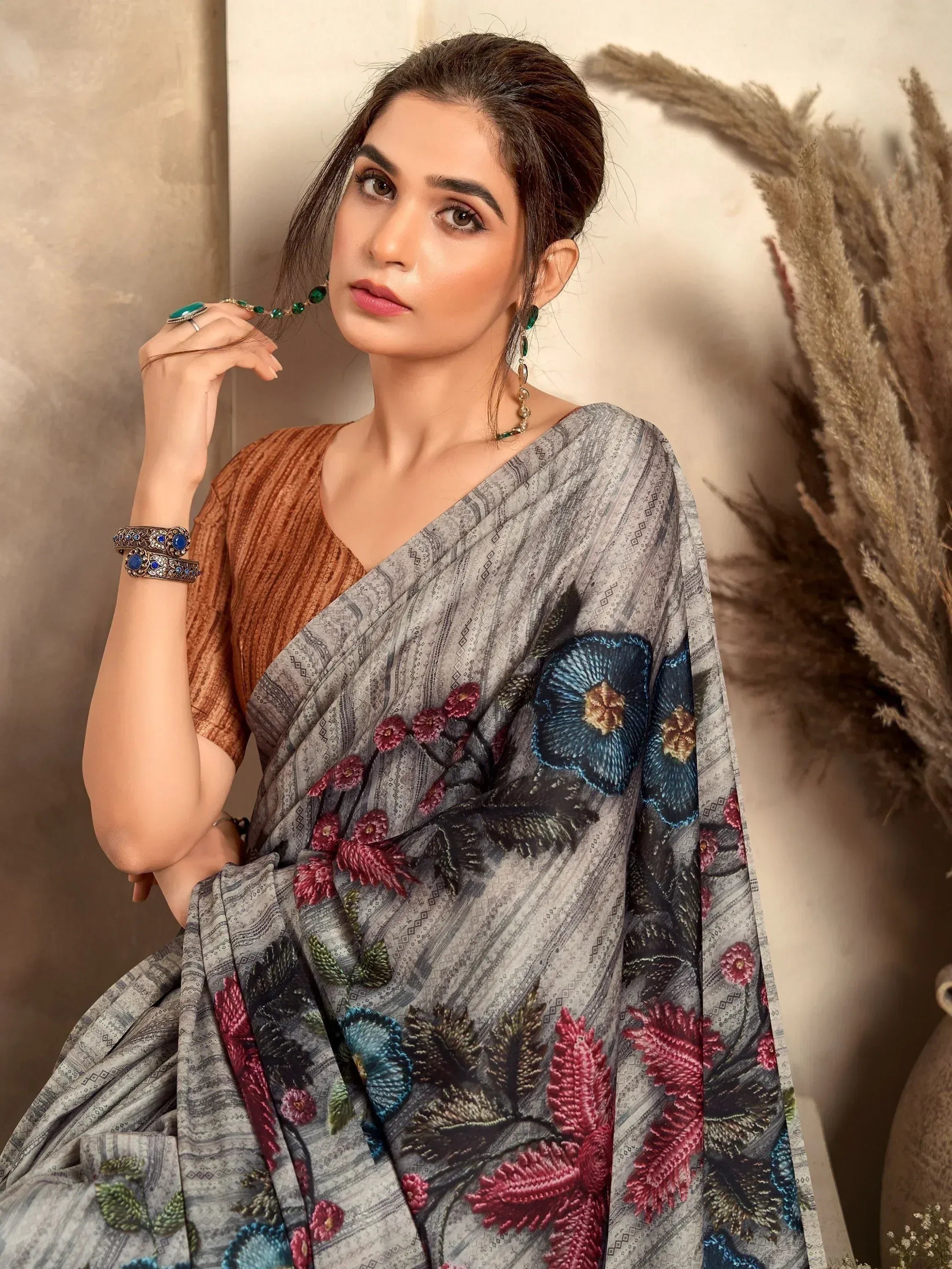 Woman in grey floral embroidered saree with rust blouse, ethnic jewelry, perfect for Indian occasions