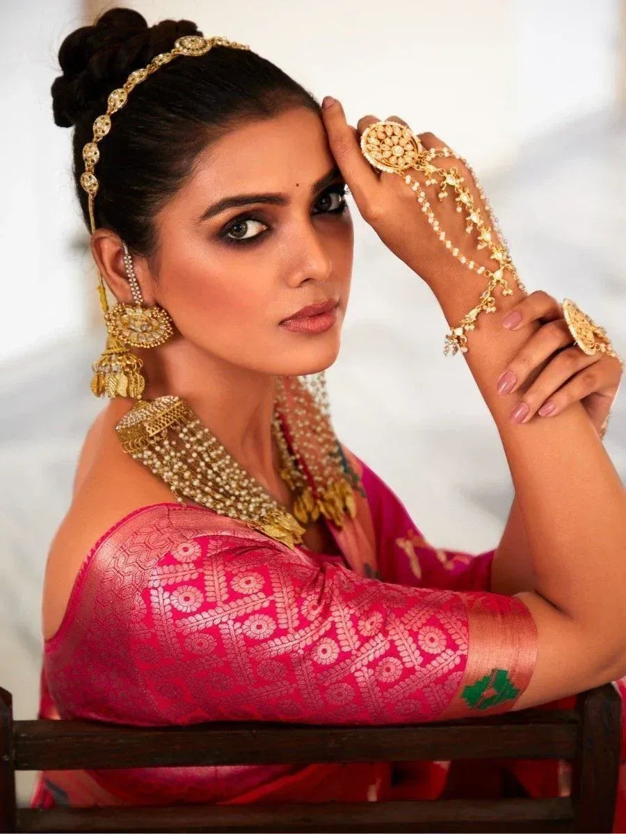 Woman in pink ethnic saree with gold jewelry, traditional Indian bridal wear