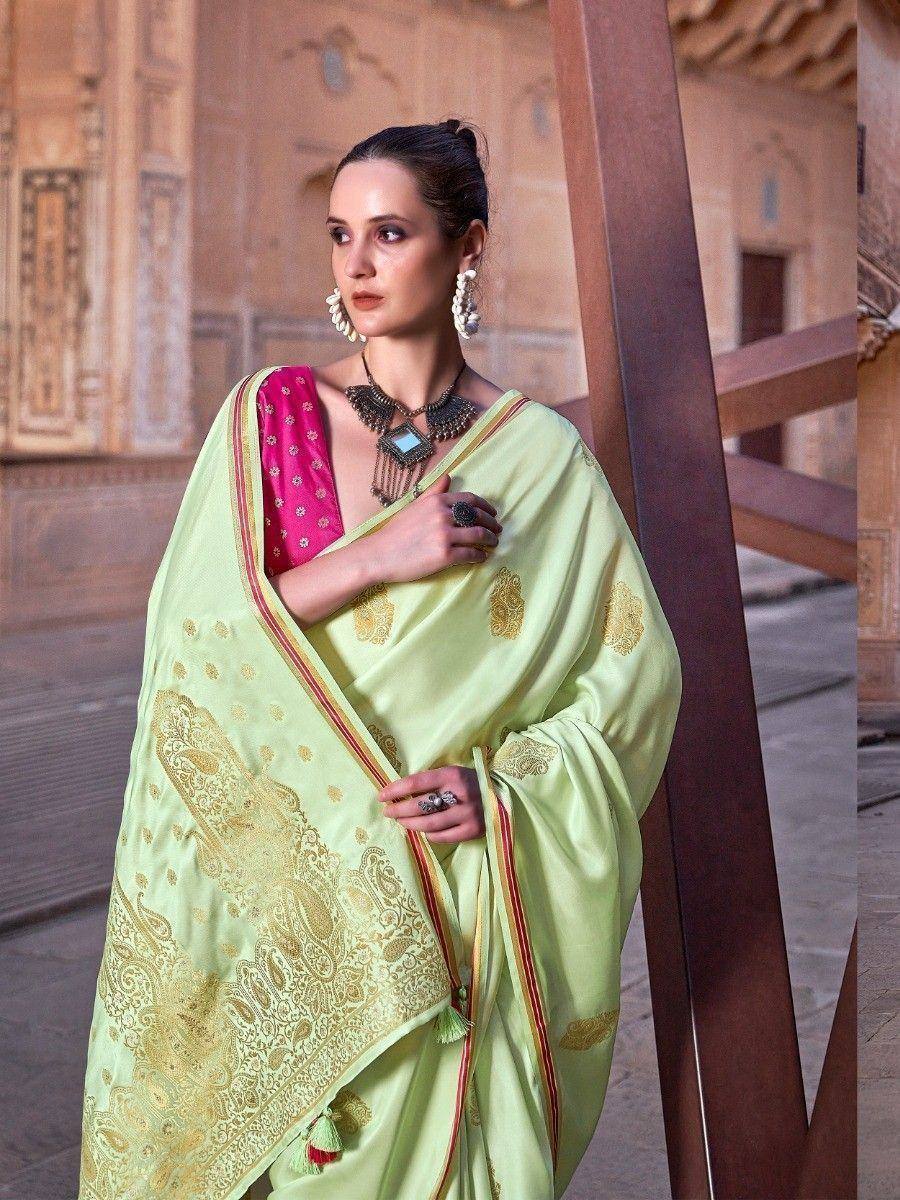 Light green designer saree with gold embroidery and pink blouse, styled with ethnic jewelry for traditional occasions