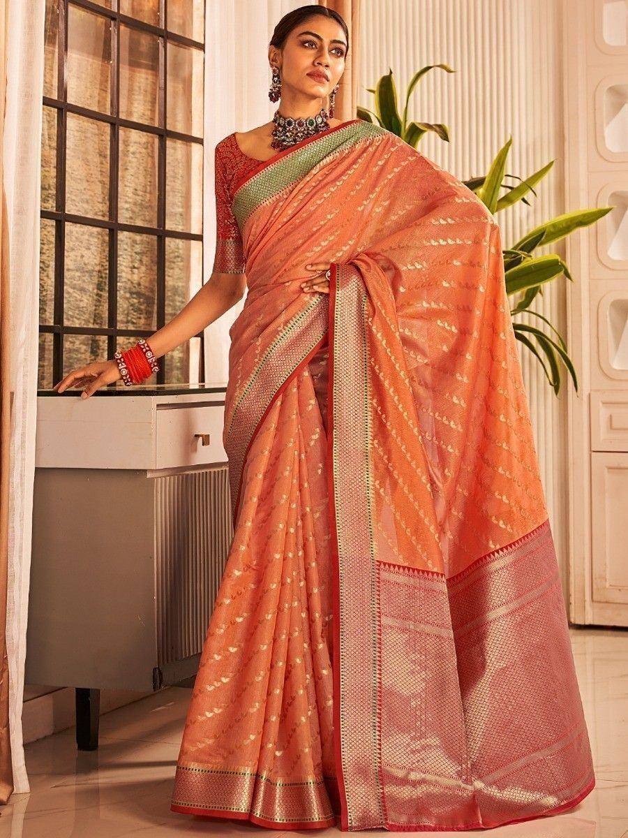 Orange designer saree with gold motifs and red border, paired with embroidered blouse for ethnic wear