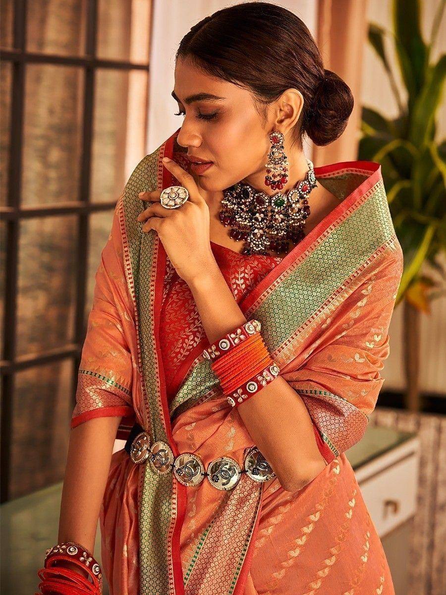 Elegant peach saree with green border, red blouse, and traditional jewelry for Indian ethnic wear