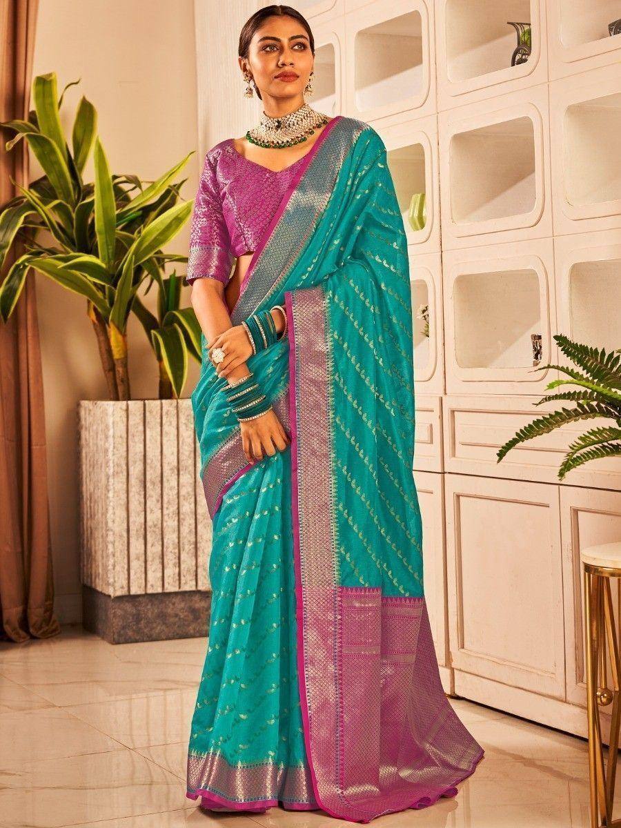 Teal and purple designer saree with gold embroidery, paired with matching blouse and traditional jewelry