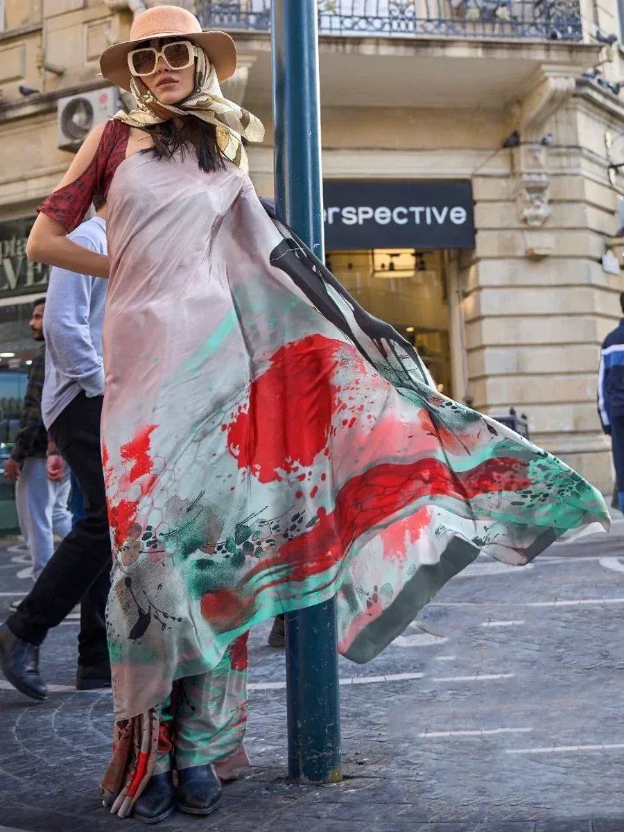 Woman in flowing abstract print ethnic gown with scarf, hat, and sunglasses on city street