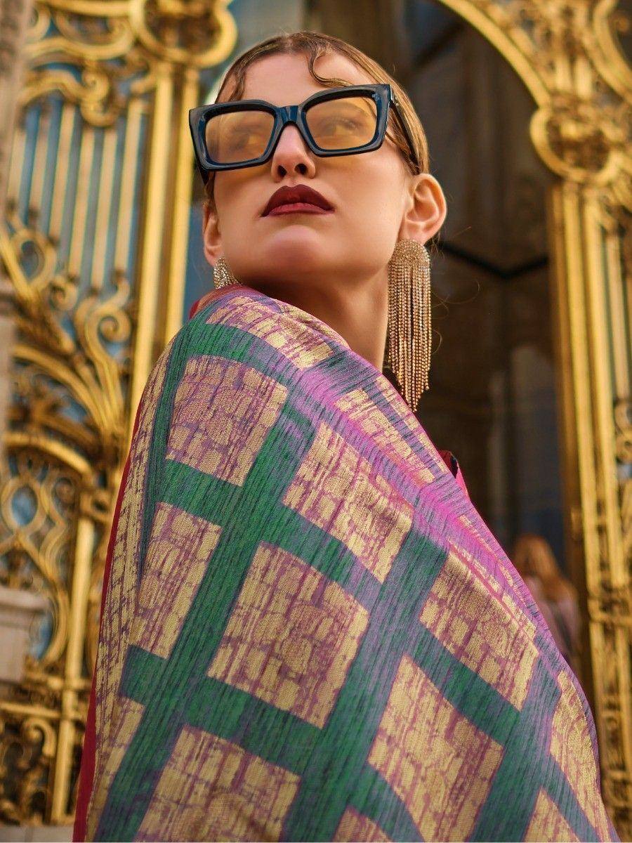 Woman in vibrant ethnic saree with green and pink checks, gold detailing, and statement earrings