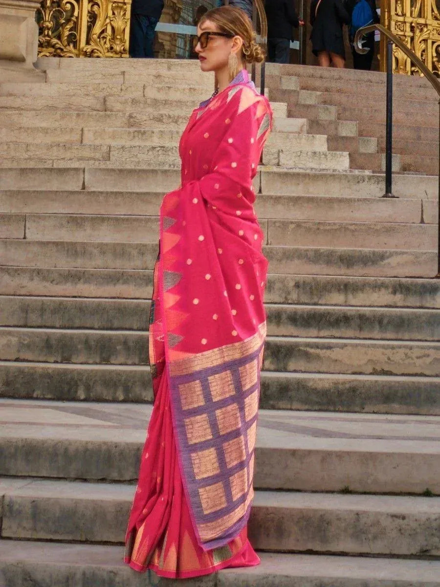 Woman in vibrant pink ethnic saree with geometric border, styled for festive occasions
