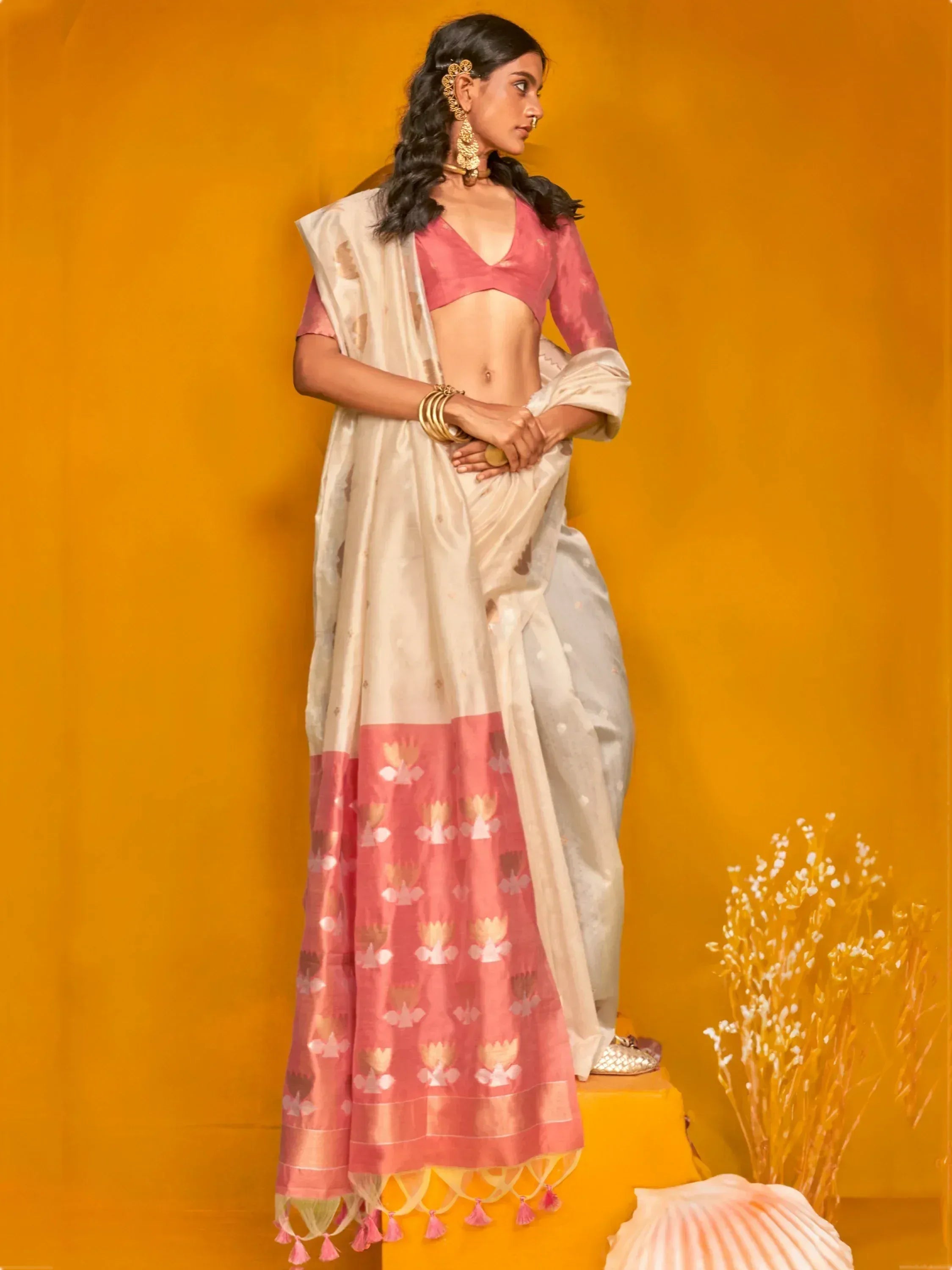 Woman in pink and cream floral lehenga choli with gold jewelry, styled for Indian ethnic wear