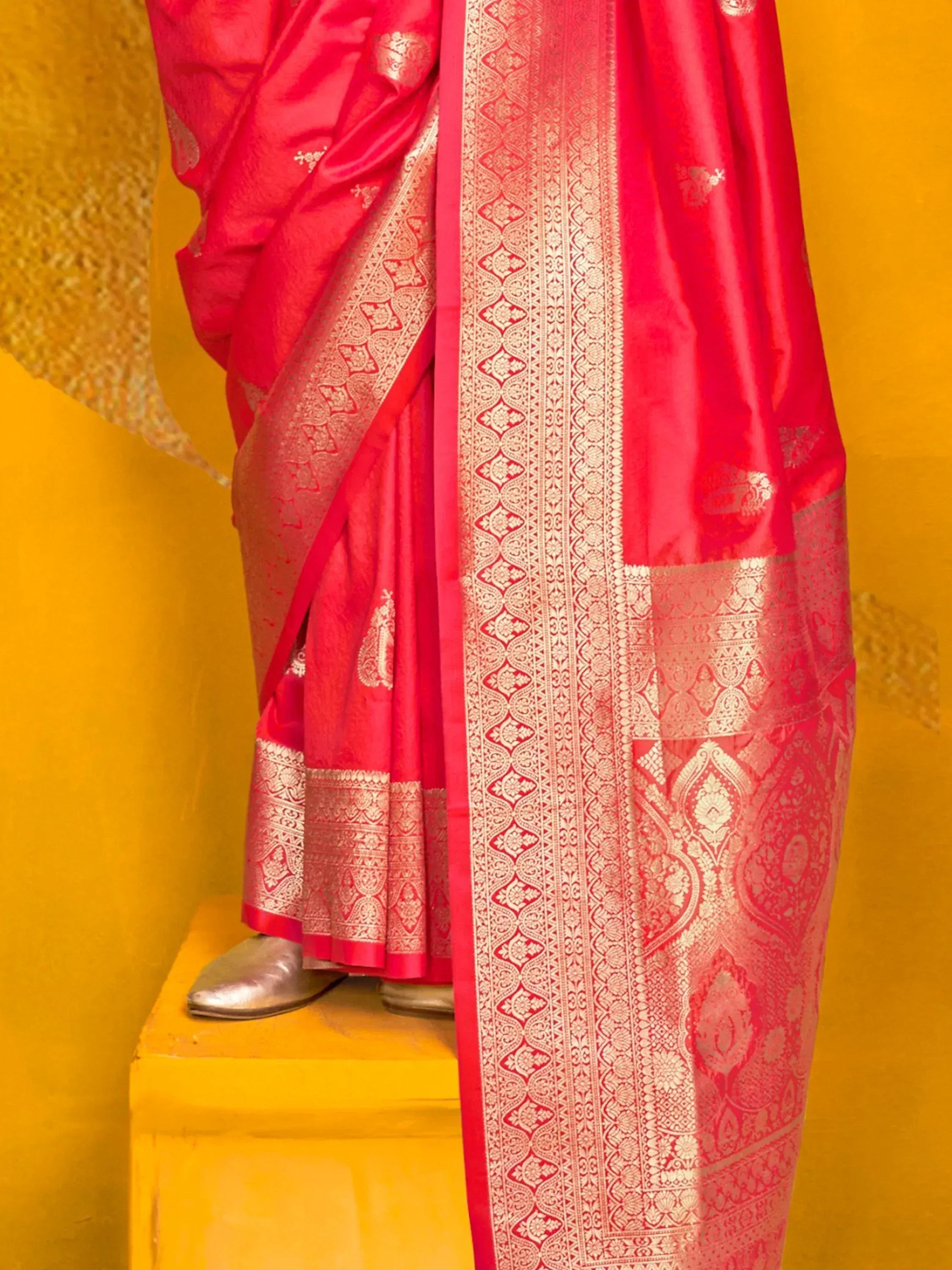 Vibrant red silk saree with intricate gold zari border and paisley motifs, perfect for Indian ethnic occasions.