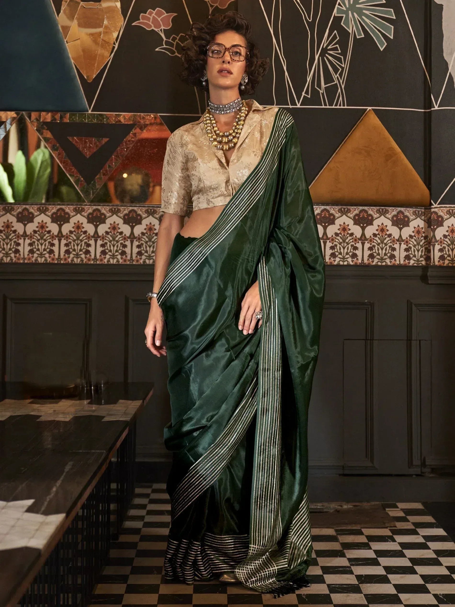 Elegant green silk saree with gold stripes, paired with a designer blouse, perfect for Indian ethnic wear.