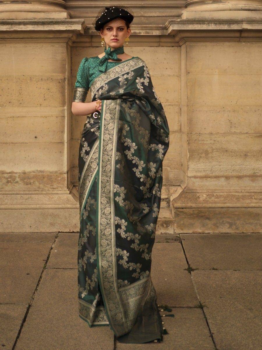 Elegant green and black floral saree with gold border, paired with matching blouse and black hat, perfect for Indian ethnic occasions.