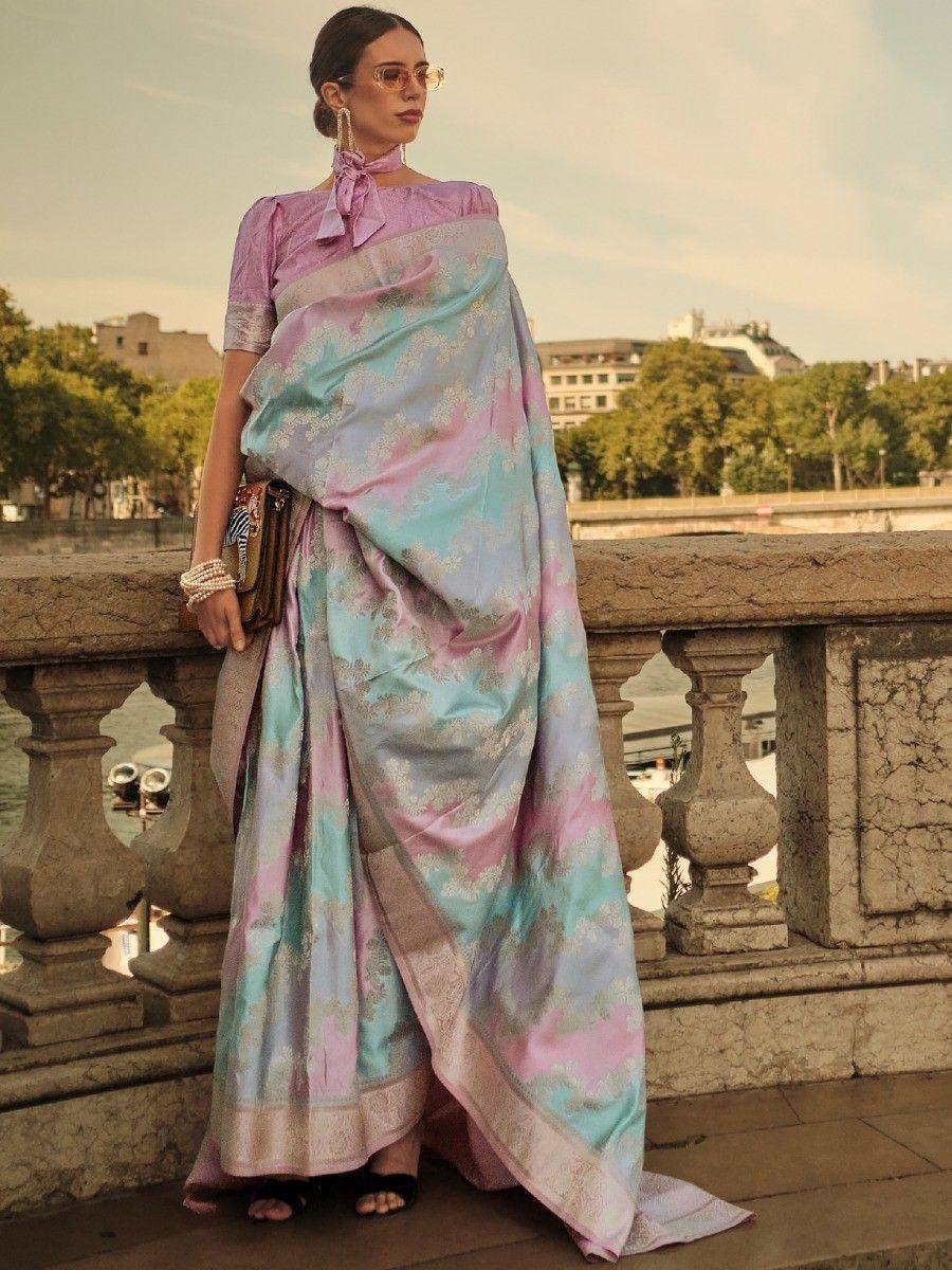 Pastel pink and blue designer saree with gold floral motifs, styled with a matching blouse and pearl accessories.