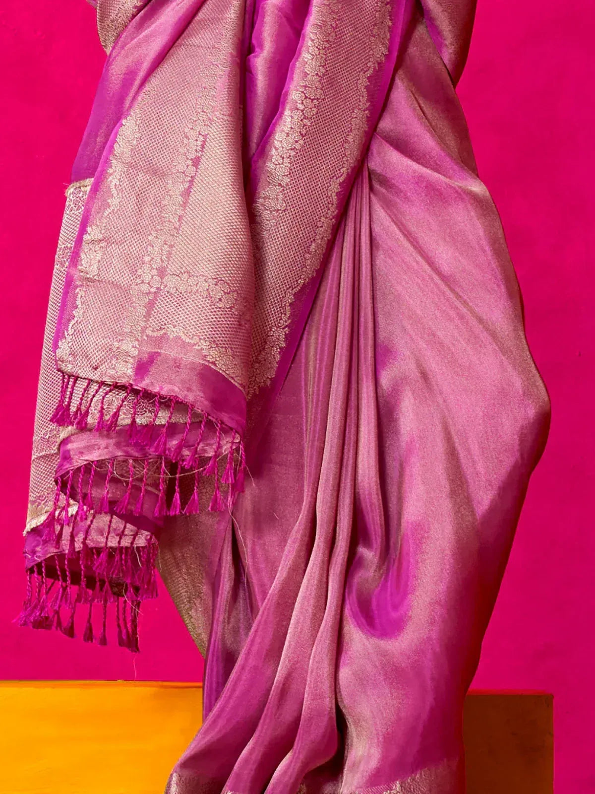 Pink silk saree with gold zari border and tassels, ideal for Indian ethnic wear occasions