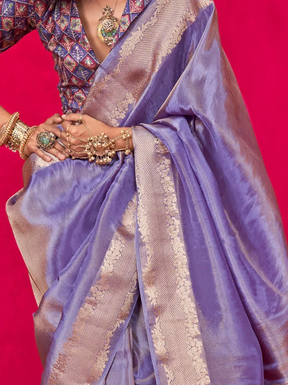 Purple silk saree with gold zari border, paired with printed blouse and traditional jewelry