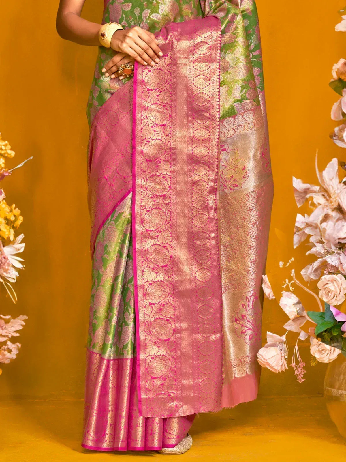 Pink and green designer saree with intricate gold embroidery and floral patterns