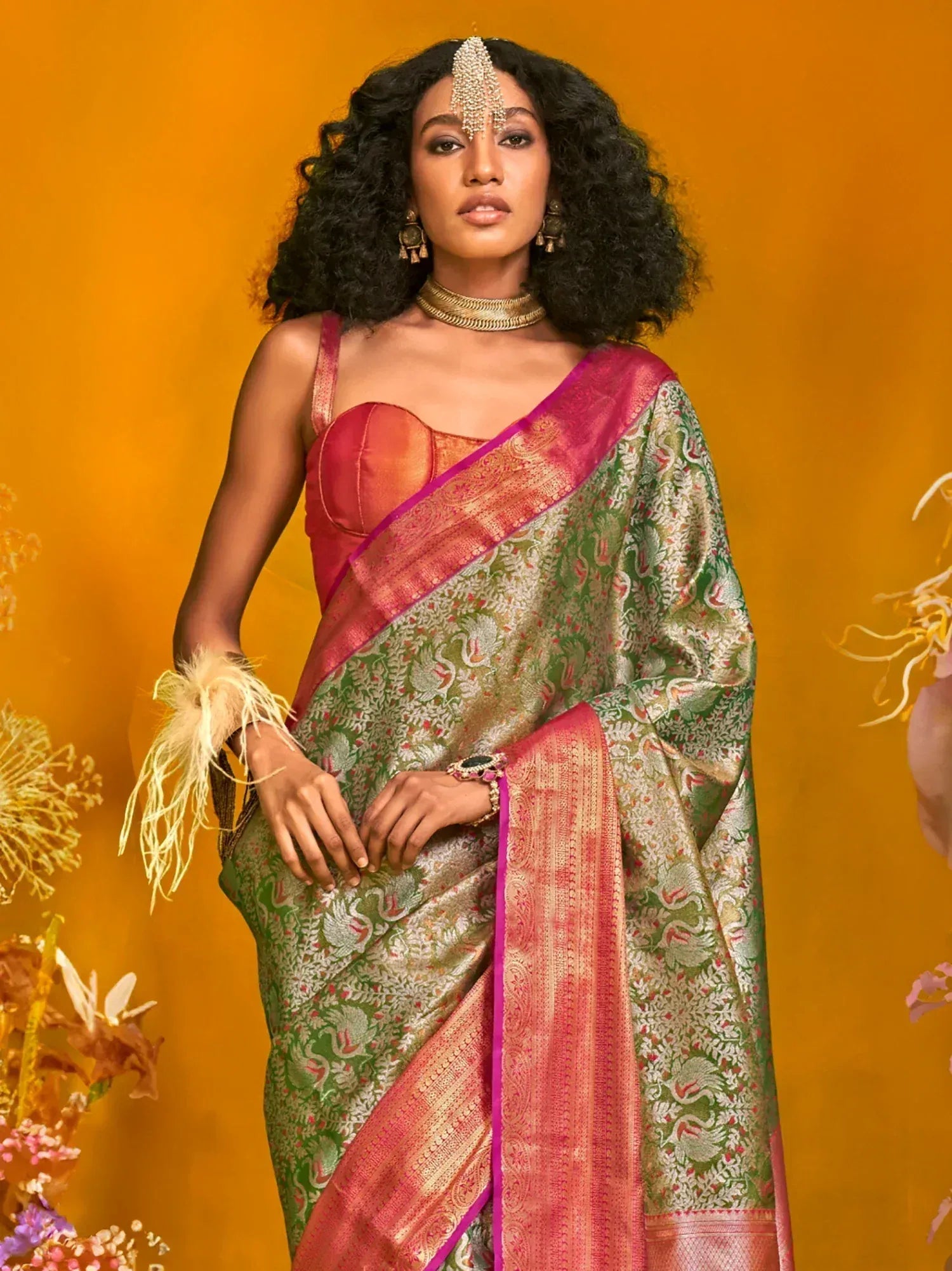 Elegant green and pink saree with intricate patterns, paired with traditional jewelry for festive occasions.