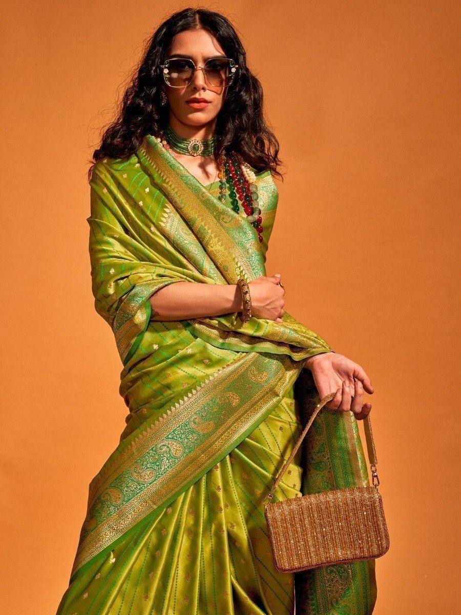 Green designer saree with gold embroidery, paired with statement jewelry and sunglasses for ethnic fashion