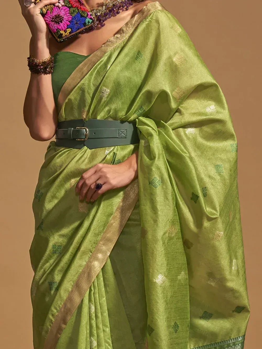 Green ethnic saree with gold border, floral clutch, and belt - Indian designer wear
