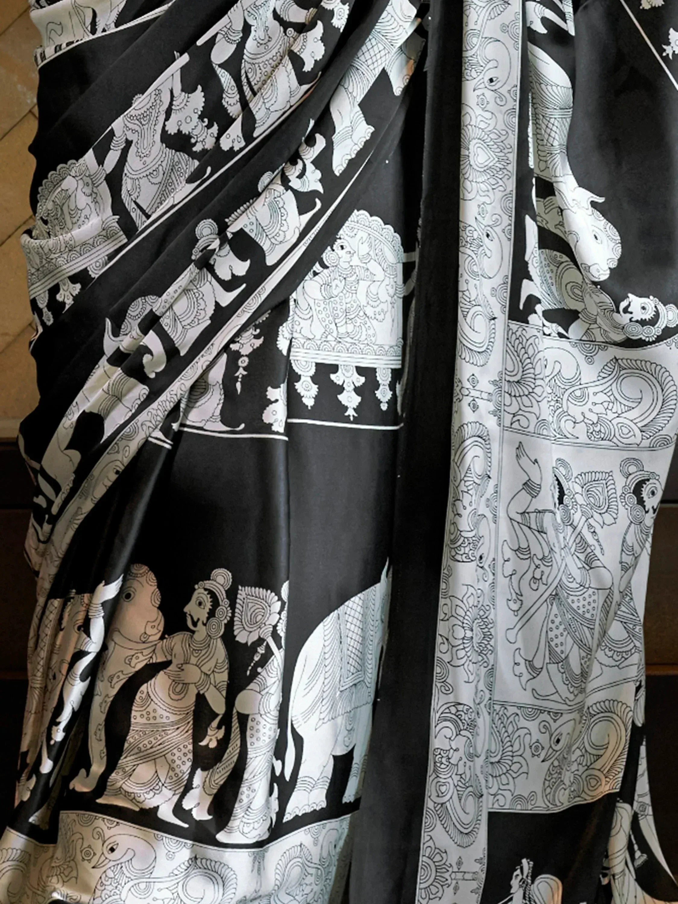 Black and white printed saree with intricate ethnic motifs and traditional Indian art designs