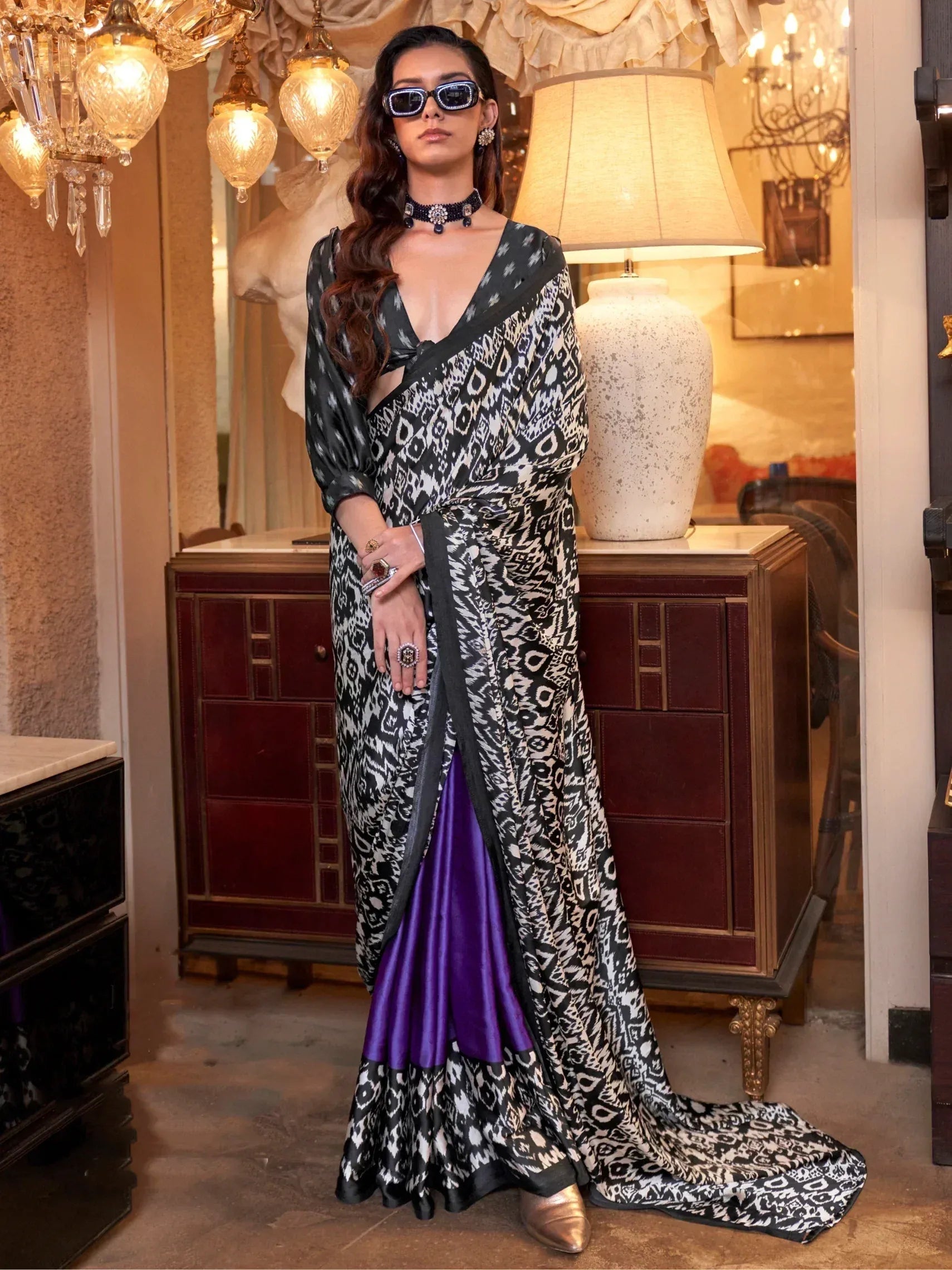 Stylish black and white ikat saree with purple lining, paired with statement jewelry and sunglasses for ethnic fashion