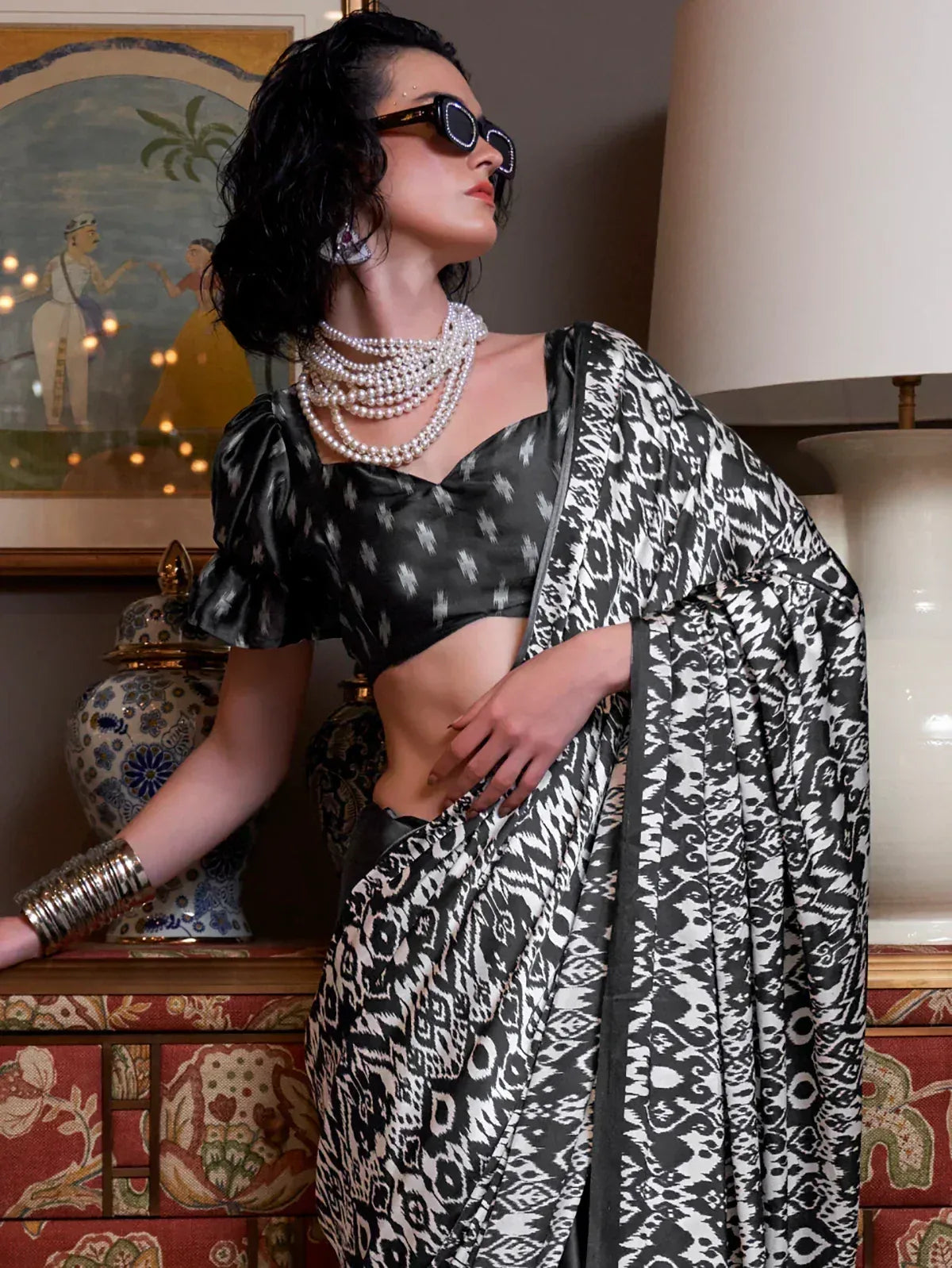 Black and white ikat print saree with puff sleeve blouse, styled with pearl necklaces and sunglasses