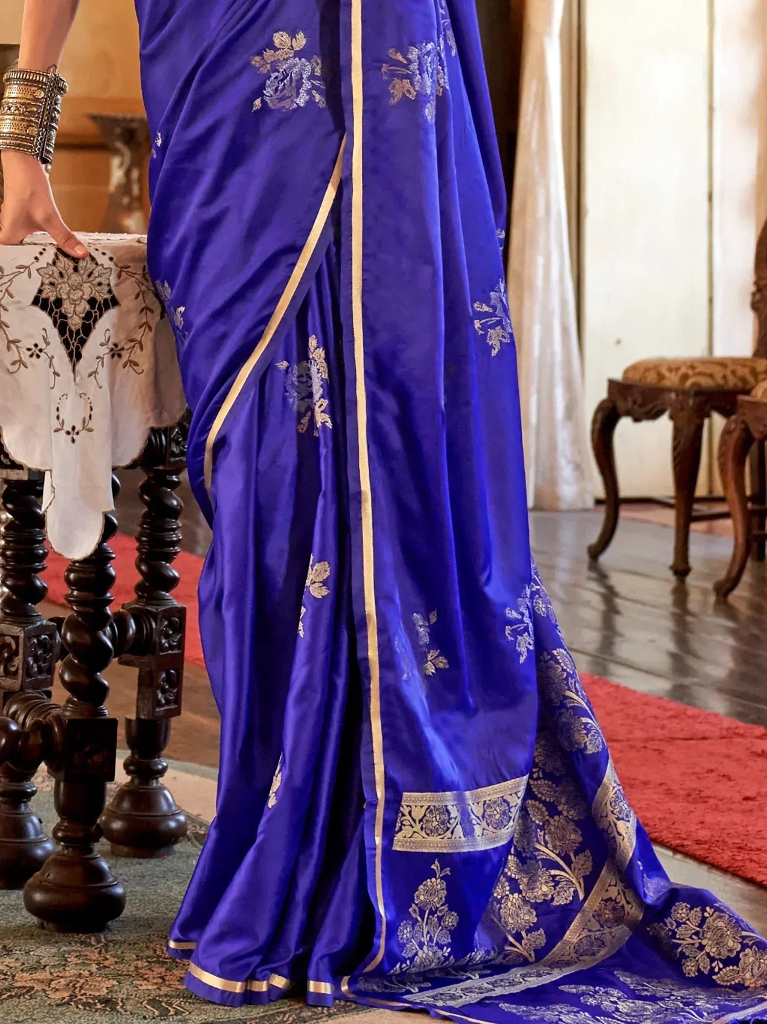 Royal blue silk saree with gold floral embroidery and border, styled with traditional bangles