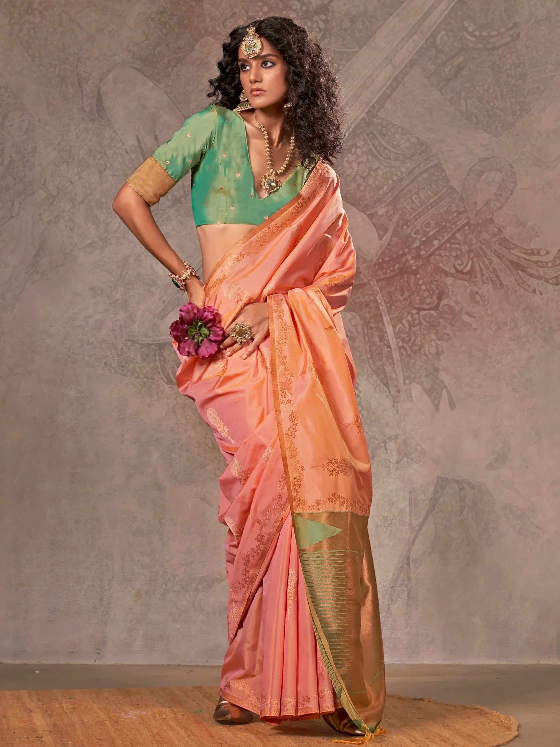 Woman in peach silk saree with gold embroidery and green blouse, traditional Indian ethnic wear