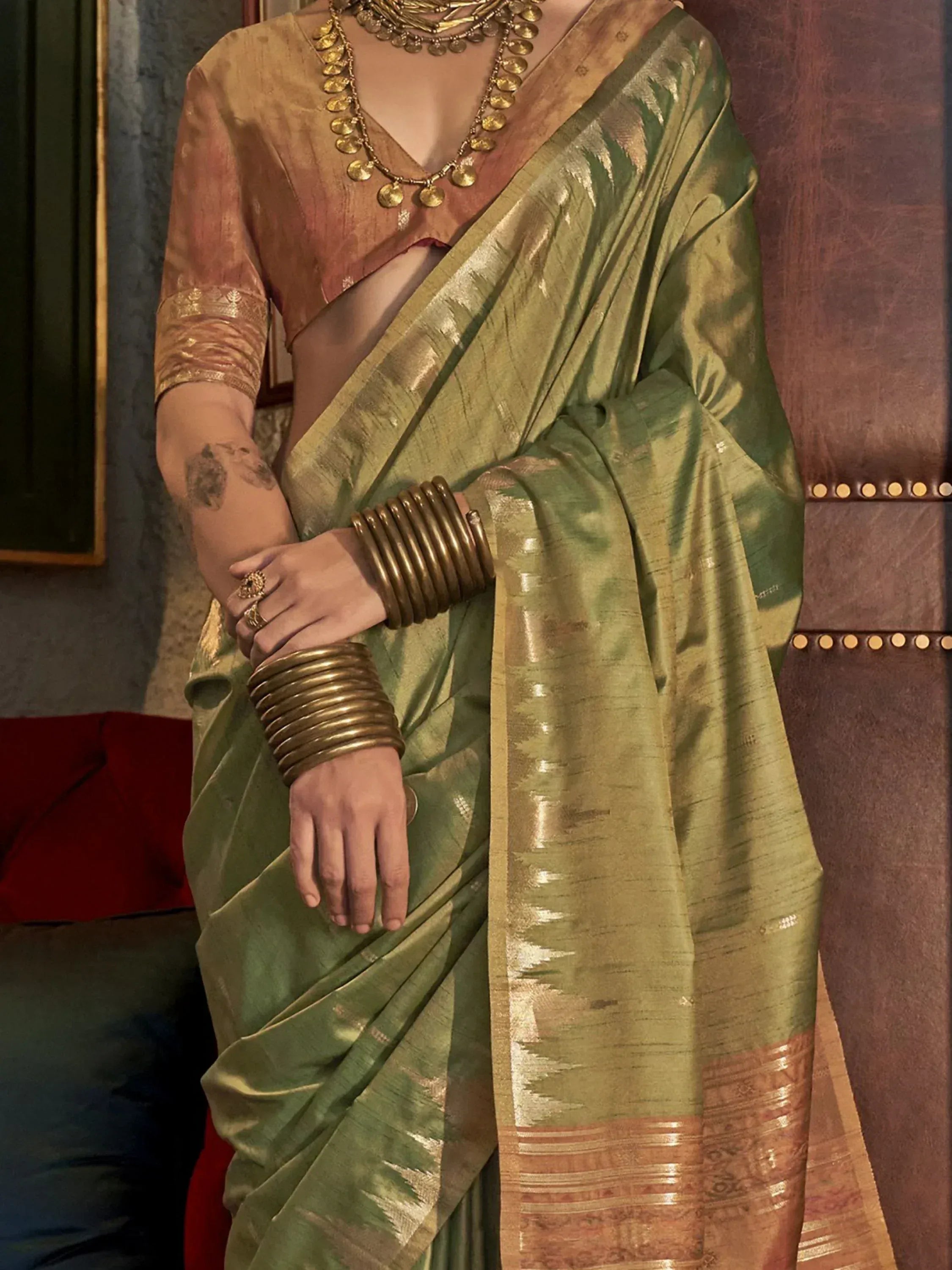 Olive green silk saree with gold border, paired with designer blouse and traditional Indian jewelry for ethnic wear.