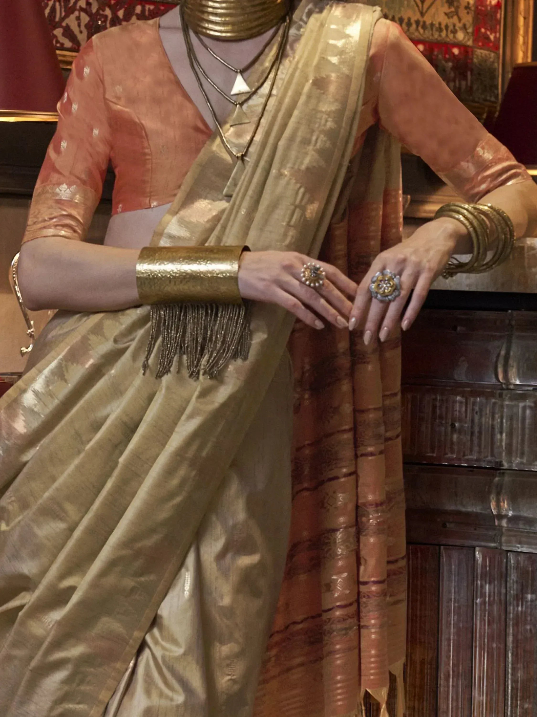 Elegant Indian saree with gold embroidery, paired with traditional jewelry and a peach blouse for festive occasions.