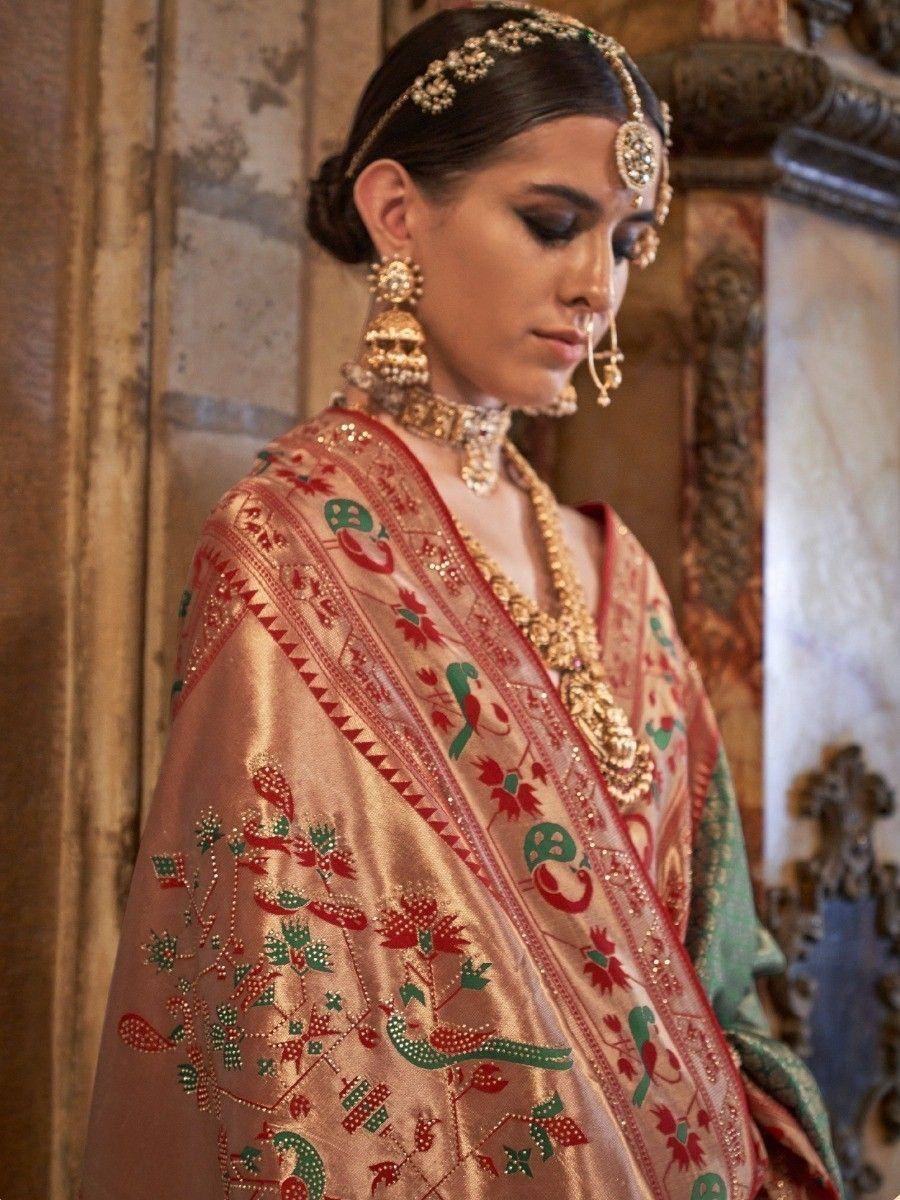 Elegant Indian bridal lehenga choli with intricate red and green embroidery, paired with traditional gold jewelry.