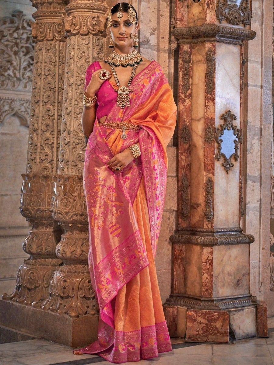 Pink and orange designer saree with gold embroidery, styled with traditional Indian jewelry for festive occasions