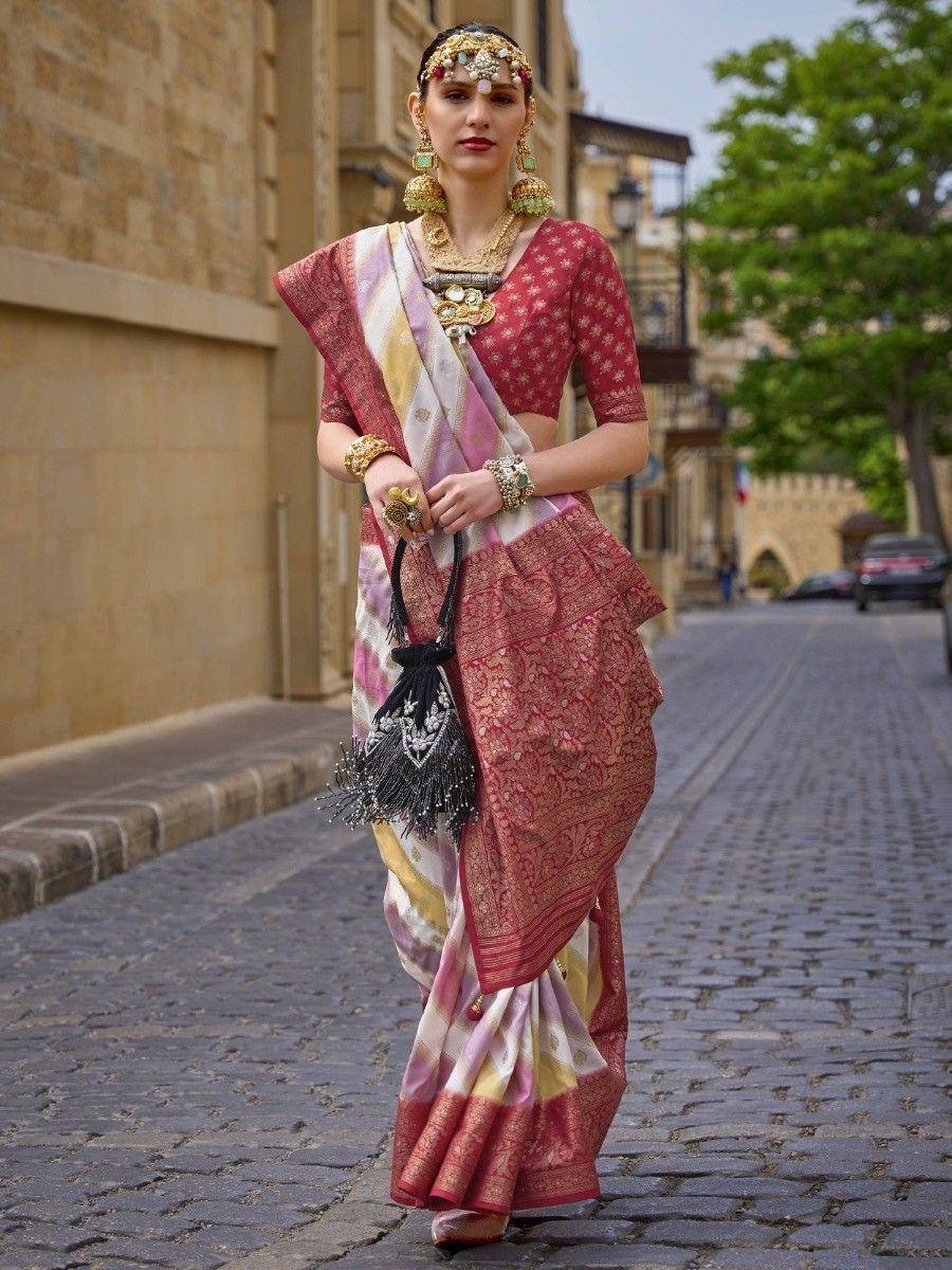 Woman in elegant Indian saree with gold jewelry, walking on cobblestone street