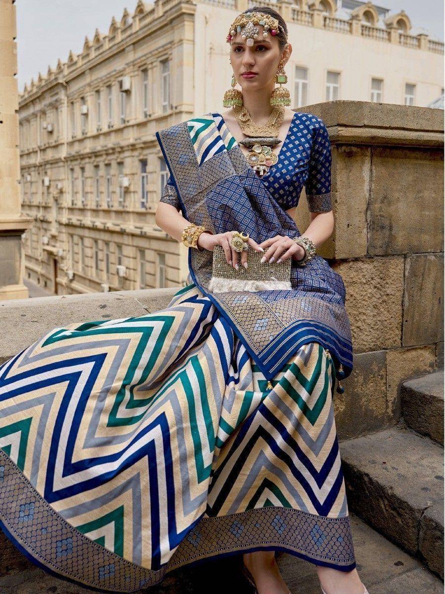 Woman in blue and green geometric print saree with gold jewelry, styled for ethnic occasions