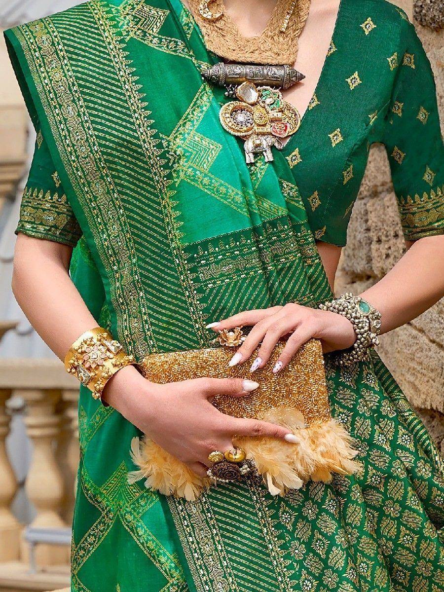 Green ethnic saree with gold embroidery, paired with statement jewelry and clutch for festive occasions