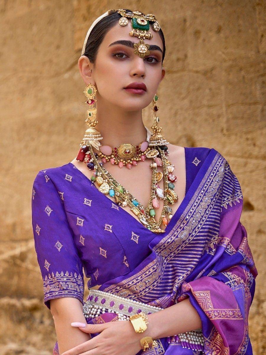 Purple ethnic saree with gold embroidery, traditional Indian jewelry, and temple-inspired headpiece