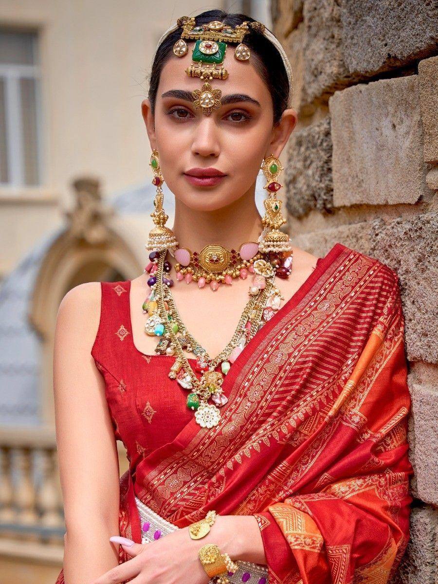 Woman in red ethnic saree with gold jewelry and temple headpiece, traditional Indian attire