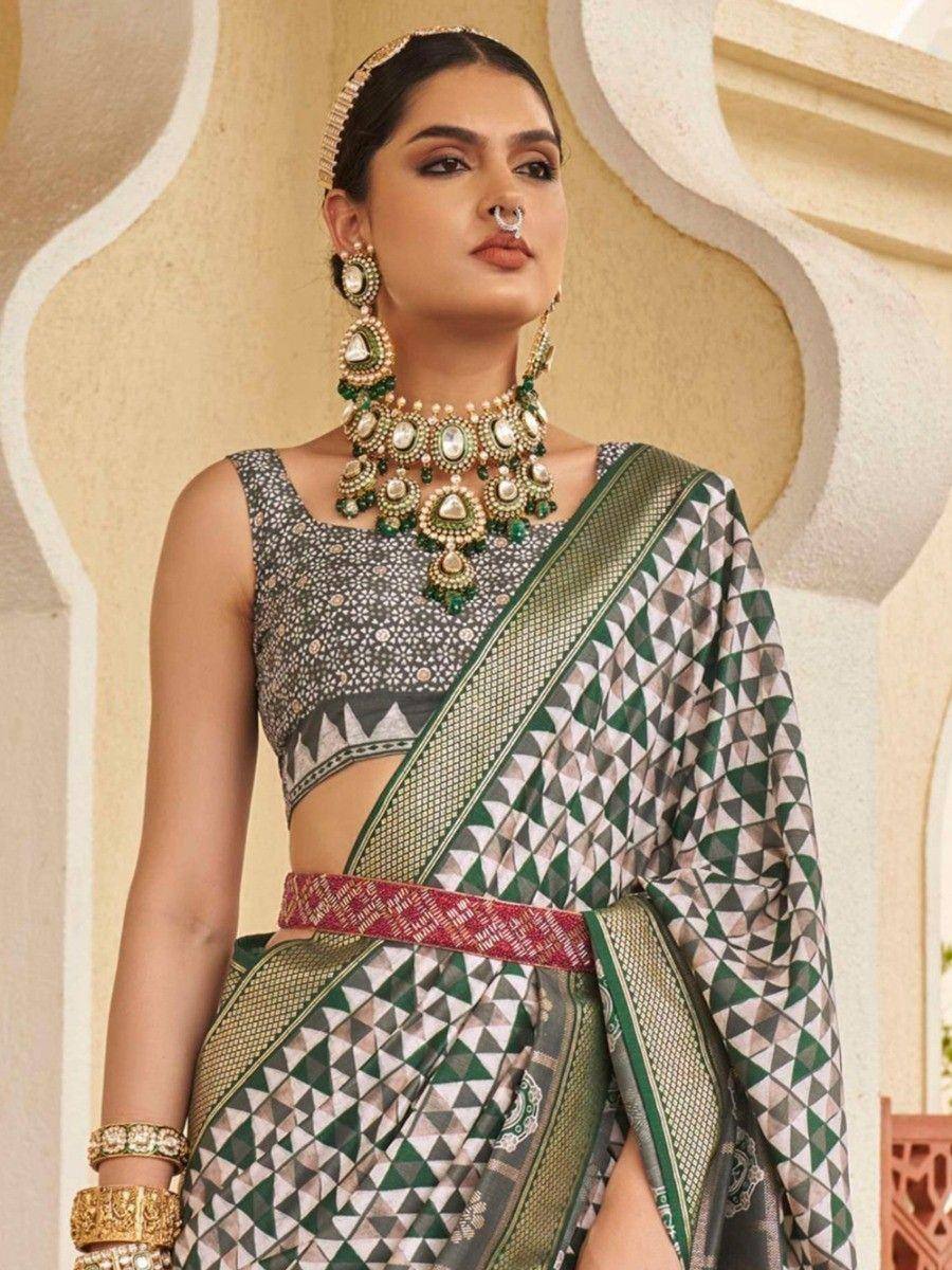 Woman in green geometric print saree with embroidered blouse and traditional jewelry
