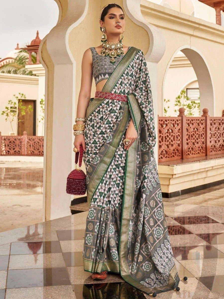 Green and grey printed saree with geometric patterns, paired with embellished blouse and traditional jewelry