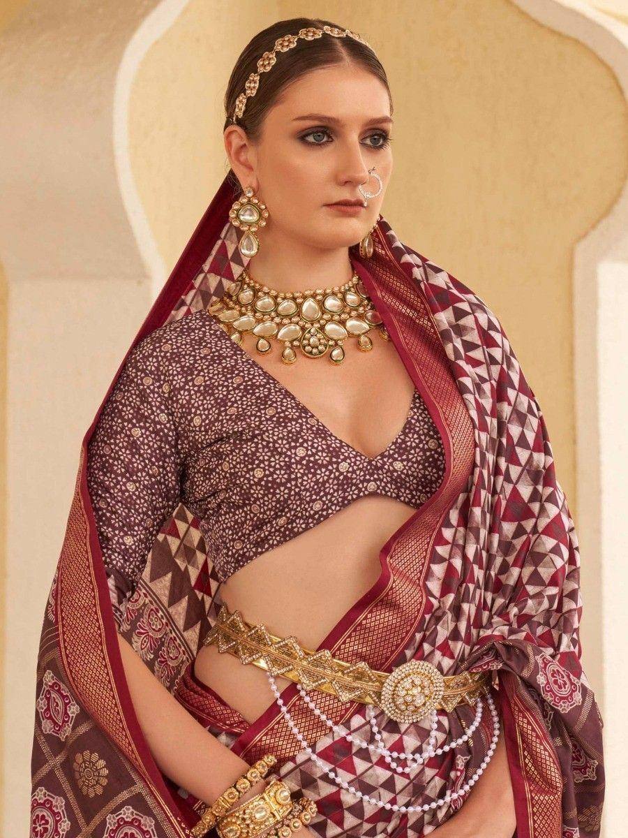 Elegant maroon ethnic saree with gold jewelry, perfect for Indian weddings and festive occasions.